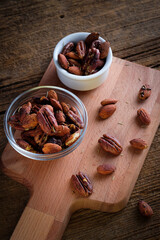 Snack to beer on wooden background. Smoked peanuts. Almonds and pecans.