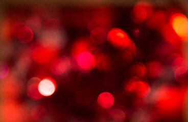 Red blurry bokeh and highlights. Disco lights. Bokeh glows on a dark background. Christmas garlands with a blurred focus in the form of a red bokeh.