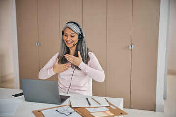 Happy smiling female teaching demonstrating hand gesture of people with hearing impairment