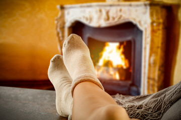 Woman legs with socks and fireplace 