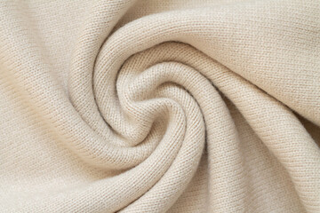 Background of woolen knit beige warm sweater top view