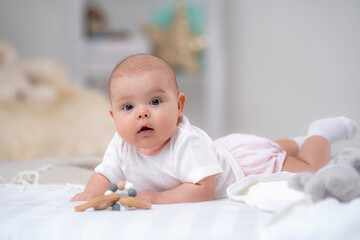cute baby lying on bed on white blanket against background children's room