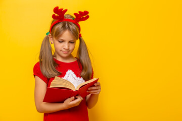 Little girl wearing antlers reading a book