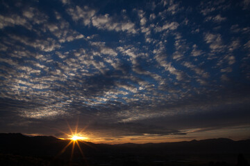 美しい光芒の夕焼けと鱗雲