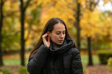 beautiful happy young brunette woman having a walk in the autumn park