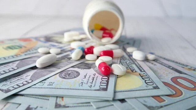 Healthcare cost concept with us dollar , container and pills on table 