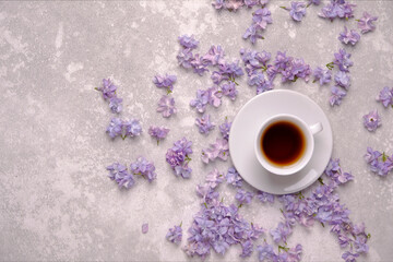 A Cup of tea on a saucer in a frame of flowers.