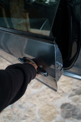 Fototapeta na wymiar Person opening the door of a modern grey car