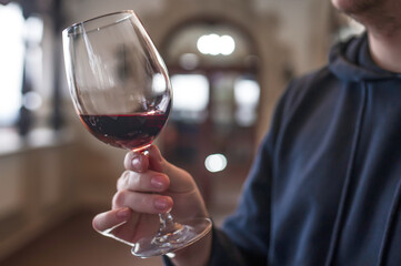 Person holding a glass of red wine