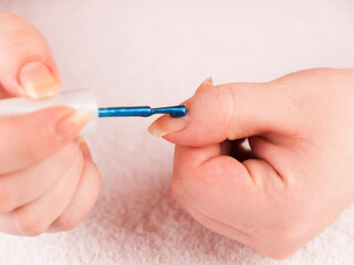 The concept of hand care. Closeup manicurist applies nail gel polish on finger. Beautician gently manicured service. Nail.