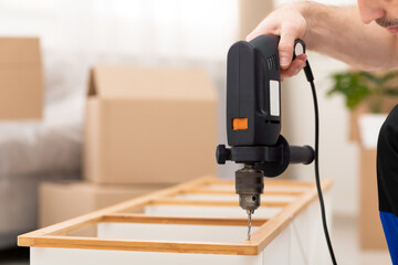 Unrecognizable Furniture Assembler Assembling Cabinet Shelf Working Using Drill Indoors