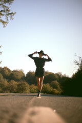 Trendy girl in the woods wearing a black dress and a fedora hat during autumn in Spain.