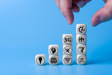 Technology concept with icons on wooden cubes, blue background.