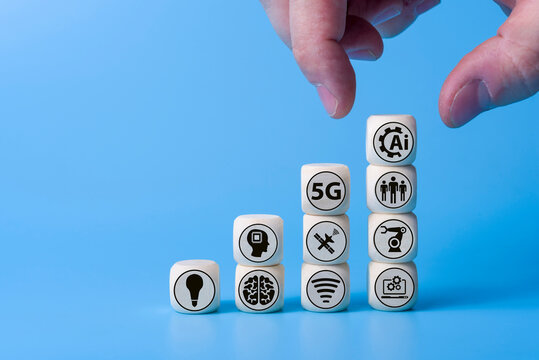 Technology concept with icons on wooden cubes, blue background.