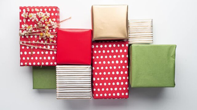 Wrapping Christmas gifts step by step on a white background. Time-lapse video. Stop motion video. New Year and Christmas.