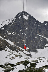 Czerwony wagonik kolejki górskiej - wciąg narciarsko turystyczny na szczyt w Tatrach Słowackich