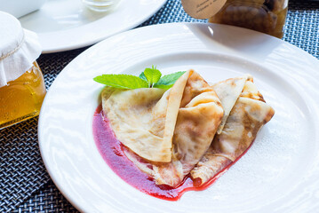 thin pancakes with strawberry jam