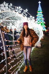 The beautiful young lady standing near Christmas fair 