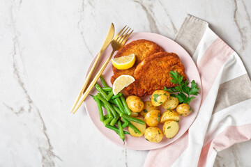 Breaded pork schnitzel with potatoes, green beans