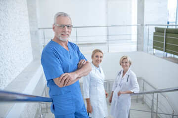 Team of smiling medical workers standing on stairs
