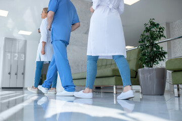 Close-up of hospital team legs walking along the hallway