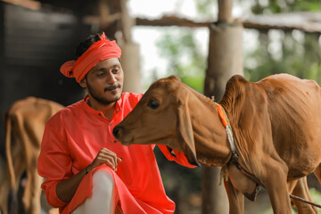 Young indian farmer with his cow at dairy farm © PRASANNAPIX