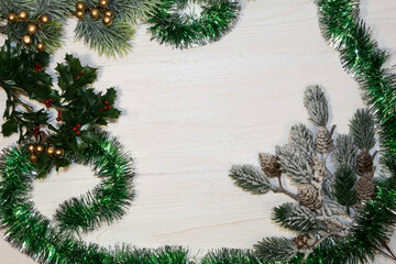 Christmas background. Decorative branches of conifers, golden balls and tinsel are framed on a light background..