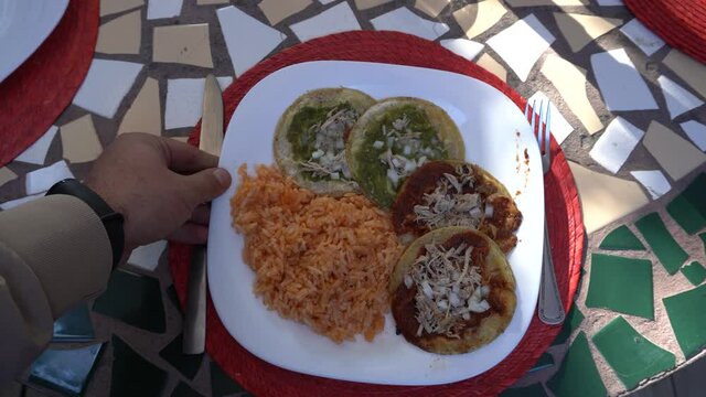 Top view of plate being served on the table with traditional mexican food chalupas and red rice