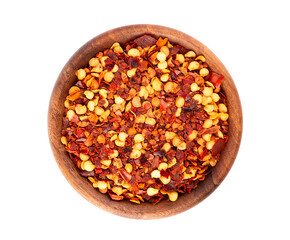 Chili and paprika in wooden bowl, isolated on white background. Mix of hot and sweet red pepper with grains. Close-up. Top view.