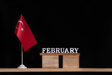 Wooden calendar of February with Turkish flag on black background. Holidays of Turkey in February .