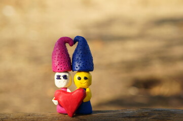 Two gnome out of clay holding a heart. Symbol of love.