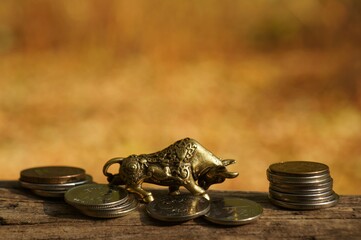 Metal bull figurine with coins close-up. A symbol of perseverance and determination.
