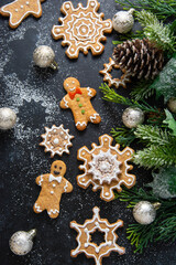 Gingerbread cookies, snowflakes shaped with icing, fir branch. Abstract Christmas food, cookies.