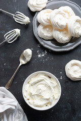 Cooking meringues Pavlova cakes from egg whites and sugar. Abstract food background, copy space. Top view.