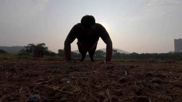 boy jumping warmup push ups pushups for chest jogging exercise semi silhouette sunrise morning exercise India Mumbai Mira road thane
