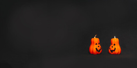 banner. orange pumpkin candles with Jack's face on a black background. preparation for the Halloween holiday
