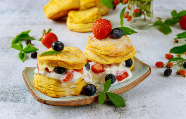 Buttermilk biscuit in plate with berries.