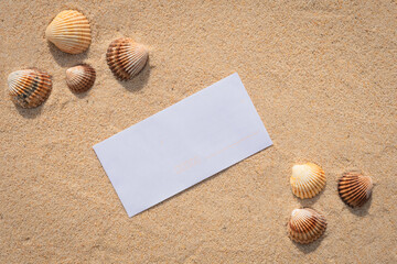 Arrière-plan grains de sable de mer, sable fin de plage avec enveloppe et galets. Emplacement pour texte sur papier.	