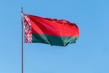 Flag of Belarus waving against blue sky