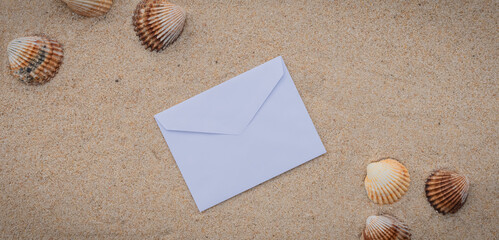 Arrière-plan grains de sable de mer, sable fin de plage avec enveloppe et galets. Emplacement pour texte sur papier.	