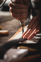 Leather handbag craftsman at work in a vintage workshop. Small business concept