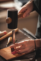 Leather handbag craftsman at work in a vintage workshop. Small business concept