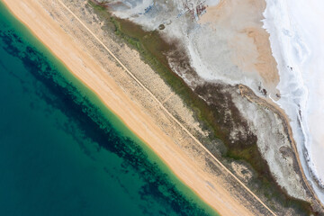 Aerial view of a salt lake separated from the sea by a sandbar. Natural background. Abstraction.