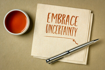 embrace uncertainty motivational note - handwriting on a napkin with a cup of tea, unknown future, change, risk and chance concept