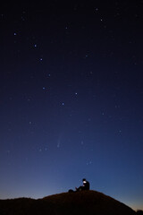 Jeune Homme Observe Regarde Son Télephone Sur Une Coline Un Soir d'Eté Sous un Ciel Étoilé avec la Comète Neowise Constellations Heure Bleue Normandie 