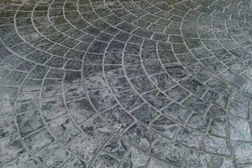Pavement with grey tiles. Footpath paved with tiled stone.