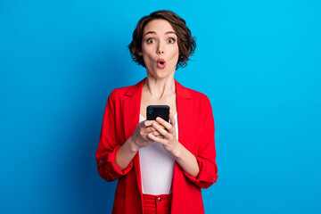 Portrait of attractive amazed stunned brown-haired lady using gadget device reaction isolated on bright blue color background