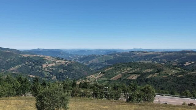 Ciclista sentado tras la subida a el puerto de o cebreiro, durante la traves&iacute;a del camino de santiago. Toma con dr&oacute;n revelando el paisaje.