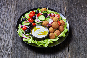 Fototapeta na wymiar Platter of falafels with vegetables with tzatziki