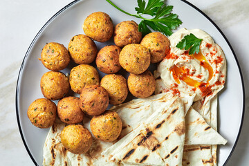 Falafels with hummus dip and flatbread on a plate